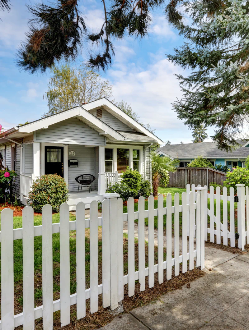 exterior view of a house with a vinyl fence and shingle roof